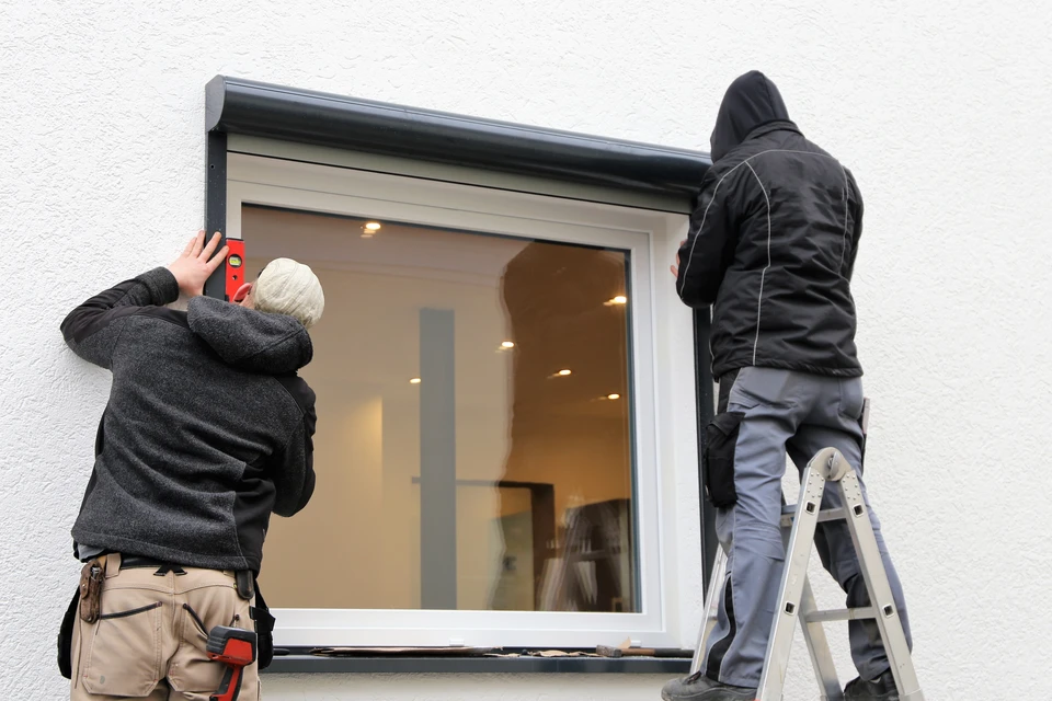 Un ouvrier de l'atelier de voiture vide le moteur en se tenant sous la voiture