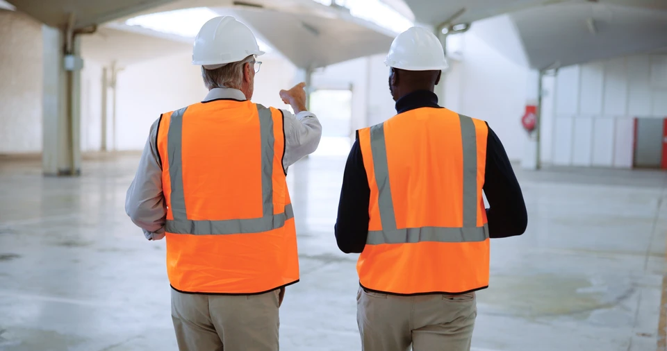 Un technicien en lunettes installe ou répare un équipement technique noir dans un environnement intérieur résidentiel